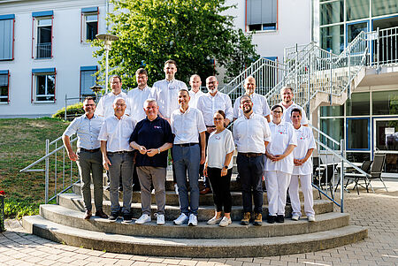 Auf der Treppe des BRK-Pflegezentrums in den Garten stehen folgende Personen: v.l.n.r. hinten: Norbert Jawansky (KBL), Marco Korhammer (LdJA), Ismet Krekic (stv. PDL), Gerhard Kletzenbauer (BGF), Robert Augustin (LGF), Michael Haller (stv. KGF), Benjamin Schäfer (TL KWW) v.l.n.r. vorne: Jürgen Sorré (1. stv. Vorsitzender), Hans-Michael Weisky (BRK-Präsident), Hermann Gröhe (DRK-Präsident), Arthur Lettenbauer (KGF), Cindy Drawert (PDL), Andreas Hanna-Krahl (BRK-Vizepräsident), Melanie Richter (stv. HWL), Manja Hager (HWL)